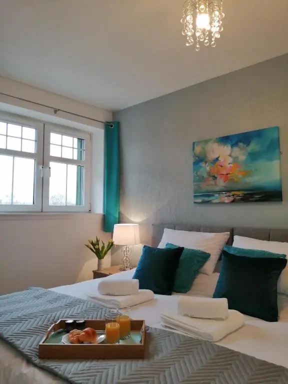 a bedroom with a bed with a tray of food on it at Seaforth House Apartment in Elgin