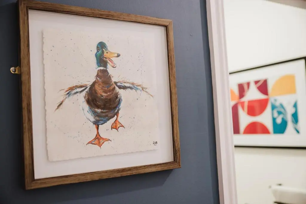 a picture of a duck in a frame on a wall at Seaforth House Apartment in Elgin