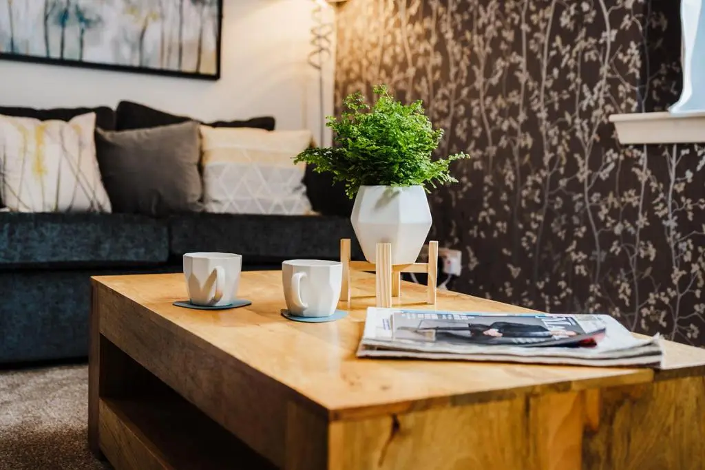 a coffee table with two cups and a vase on it at Seaforth House Apartment in Elgin