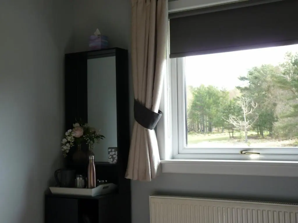 a bathroom window with a mirror and a sink at Tanleys B&B in Grantown on Spey