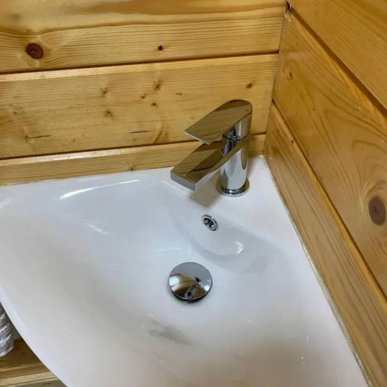 a white sink in a bathroom with a wooden wall at Immaculate cabin 5 mins to Inverness dogs welcome in Inverness