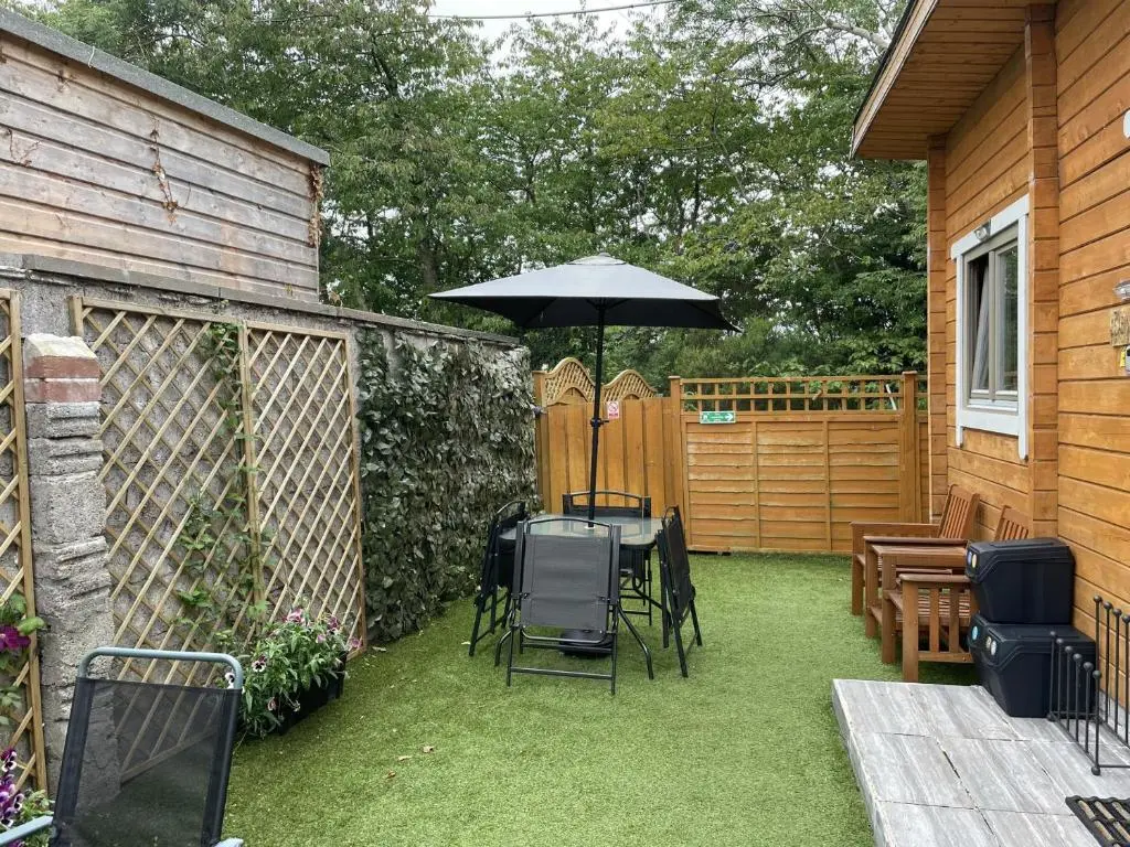 a patio with an umbrella and a table and chairs at Immaculate cabin 5 mins to Inverness dogs welcome in Inverness