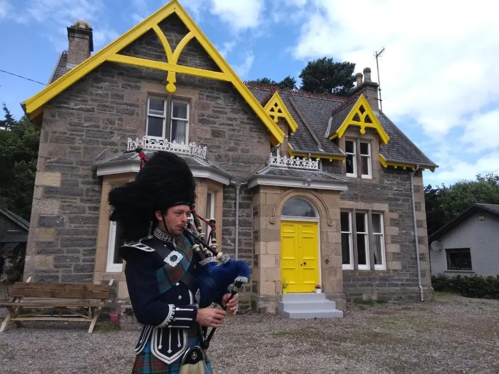 a man in uniform standing in front of a house at Ardvonie House in Kingussie