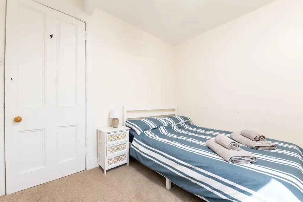 a bedroom with a bed with towels on it at Seaview House - A Traditional Home by the Beach in Nairn