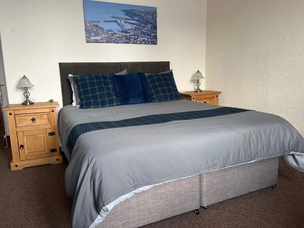 a bedroom with a large bed with two night stands at Harbour bridge, Camps bar in Wick