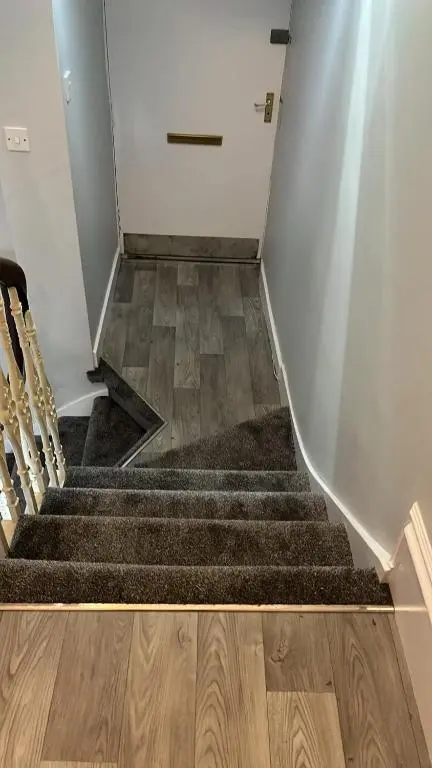 a stairway with a door and a staircase with wooden floors at Harbour bridge, Camps bar in Wick
