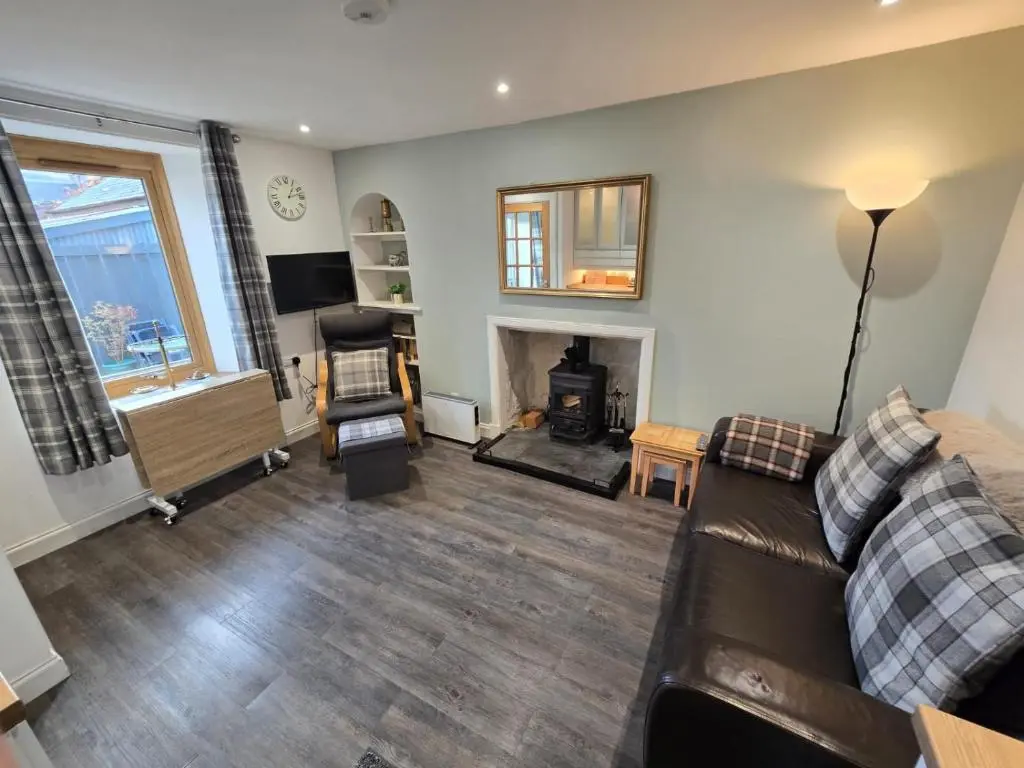 a living room with a couch and a fireplace at Pannanich View Cottage, Ballater in Ballater