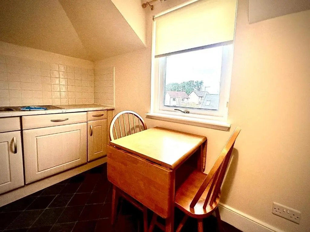 a kitchen with a wooden table and a window at Grampian Serviced Apartments - Treetops Apartments in Elgin