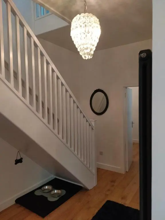 a staircase with a chandelier and some plates on the floor at Shadow's Cottage situated in Fishertown, Nairn. in Nairn