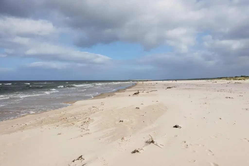 a beach with footprints in the sand and the ocean at Shadow's Cottage situated in Fishertown, Nairn. in Nairn