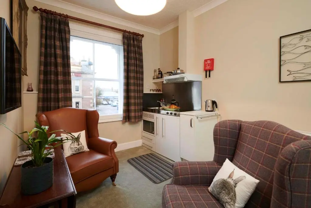a living room with a couch and a chair at Downright Gabbler in Beauly
