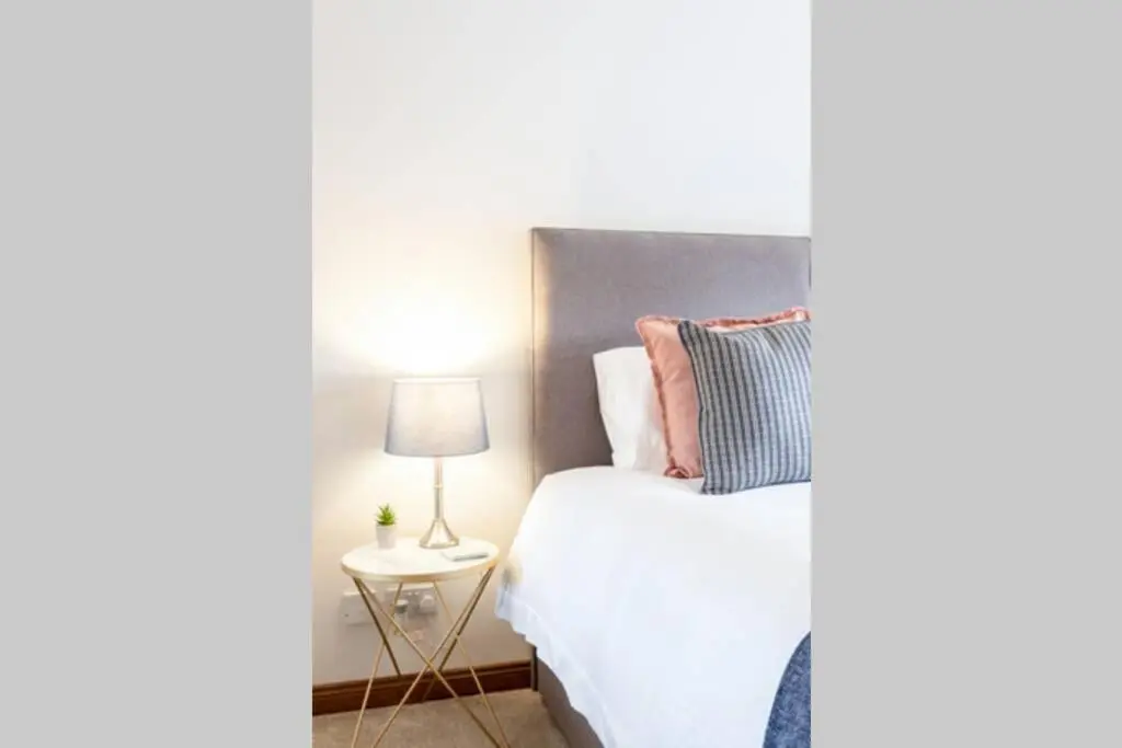 a bedroom with a white bed and a lamp at Bowmore in Lossiemouth