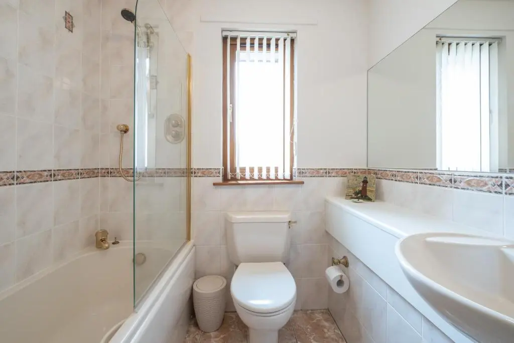 a bathroom with a toilet and a tub and a sink at Bowmore in Lossiemouth