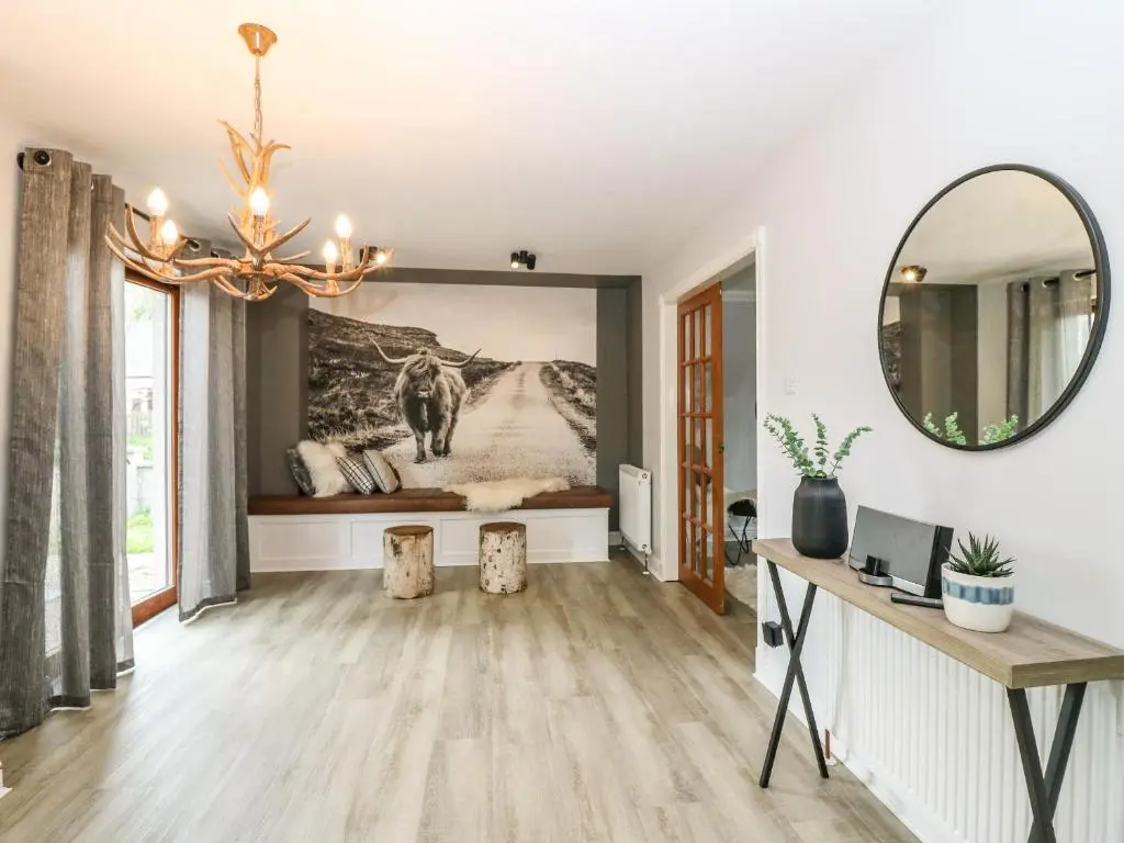 a living room with a mirror and a desk at Tombeck in Tomintoul