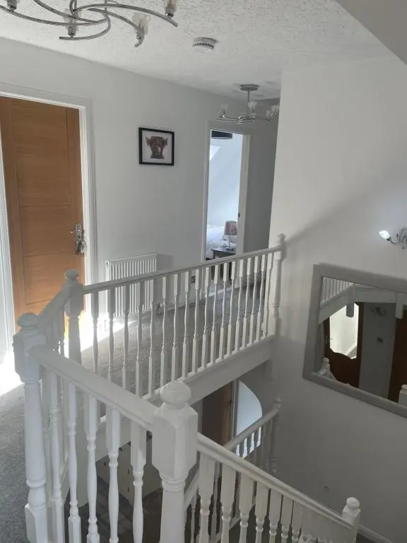 a white stairway with a mirror and a mirror at Gleneden House in Tore