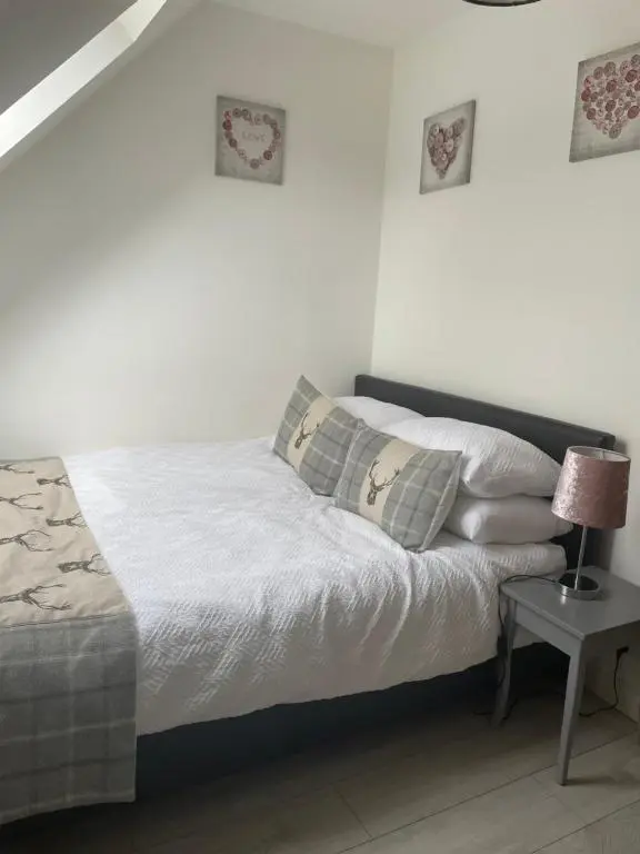 a bed with white sheets and pillows in a bedroom at Gleneden House in Tore