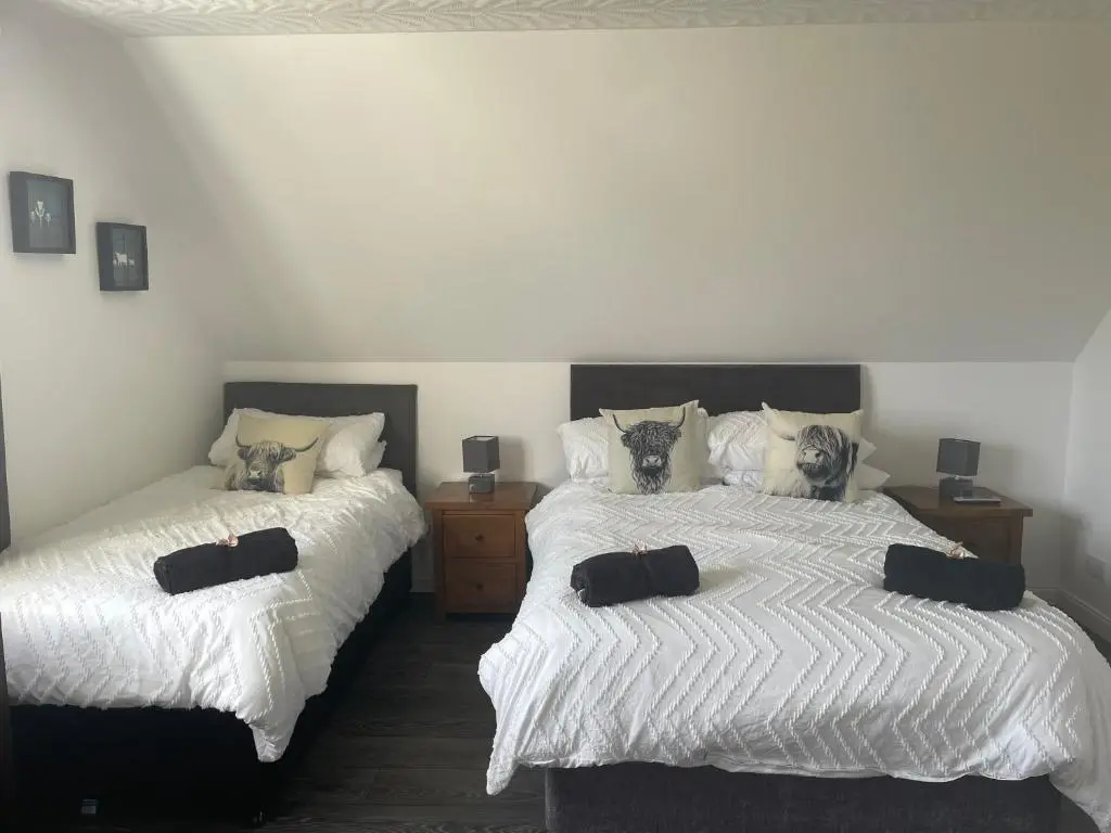 two beds sitting next to each other in a bedroom at Gleneden House in Tore