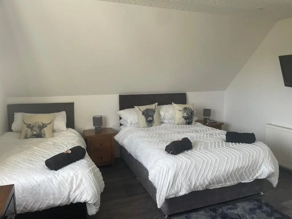 two beds sitting next to each other in a bedroom at Gleneden House in Tore