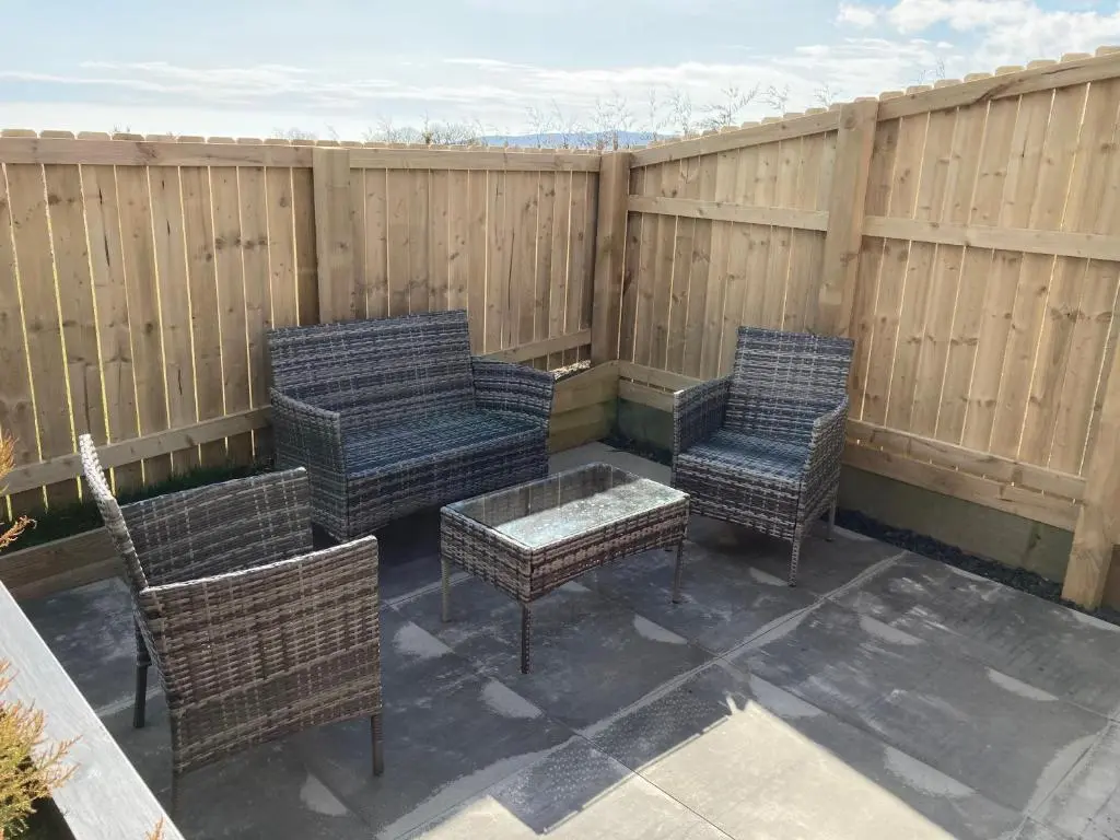 four wicker chairs and a table on a patio at North Coast Escapes in Thrumster