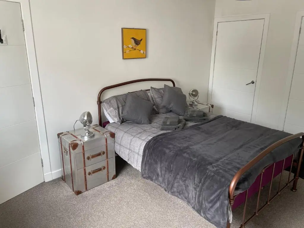 a bedroom with a bed and a nightstand next to it at Woodside retreat holiday home in Aviemore in Aviemore