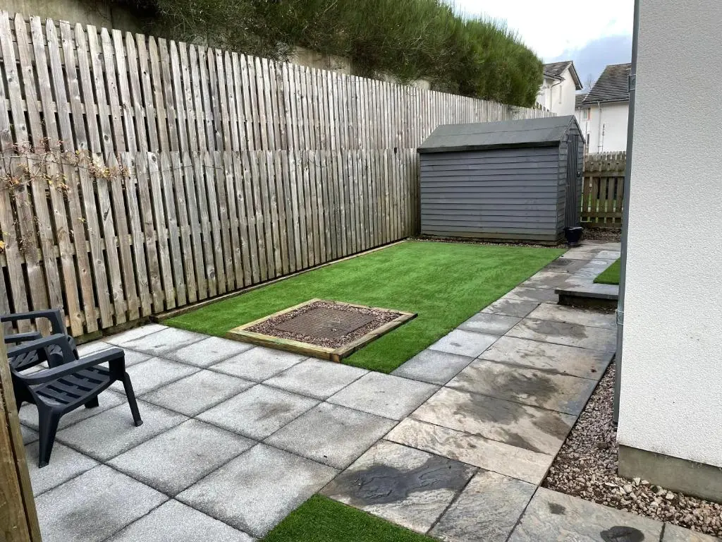 a small garden with a fence and a shed at Woodside retreat holiday home in Aviemore in Aviemore