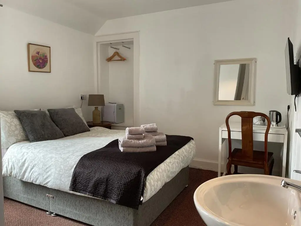 a bedroom with a bed and a bath tub at Richmond House Hotel in Fort Augustus