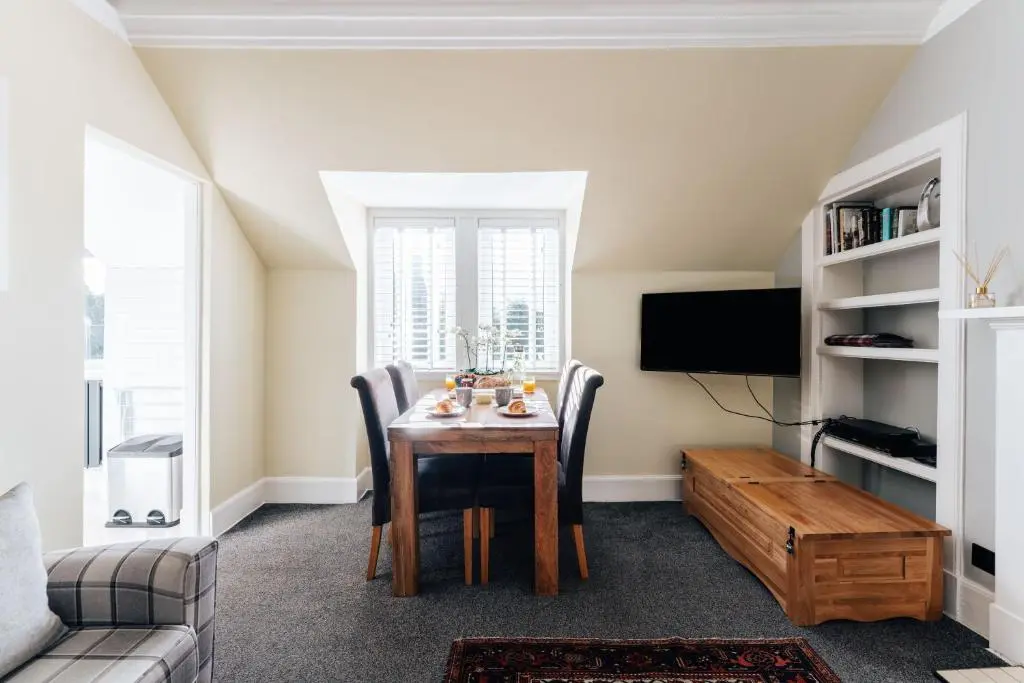 a dining room with a table and a tv at Luxury Inverness central apartment private parking in Inverness