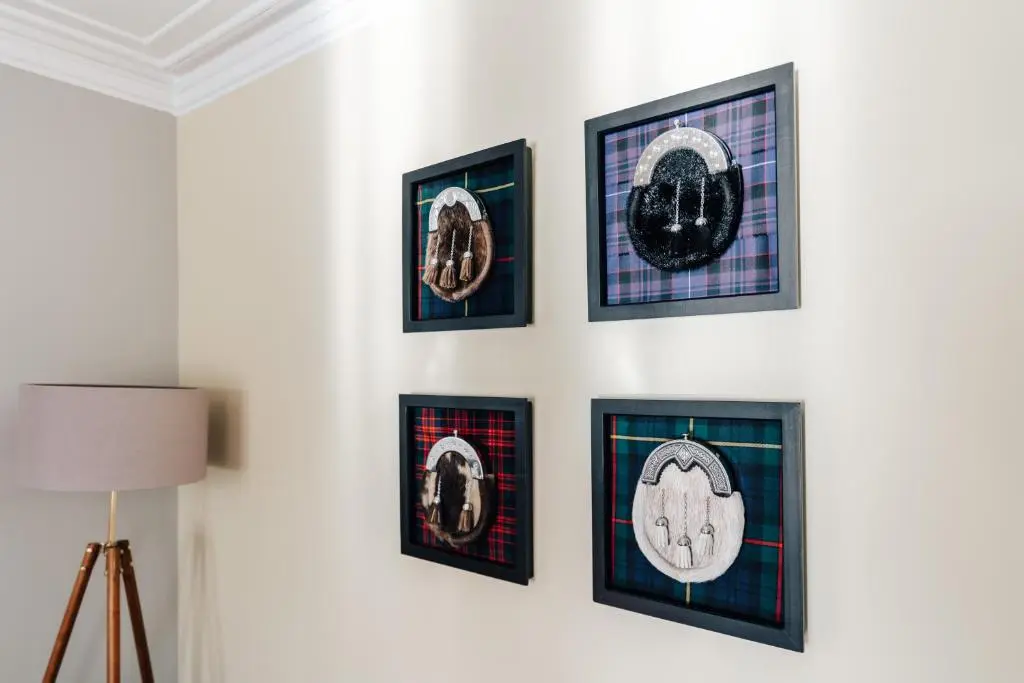 a group of framed pictures on a wall at Luxury Inverness central apartment private parking in Inverness