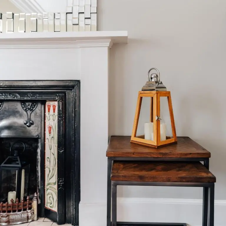 a table with a lantern next to a fireplace at Luxury Inverness central apartment private parking in Inverness