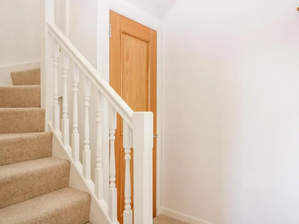 a stairway with a wooden door in a house at Tammie Norrie Cottage in Banff