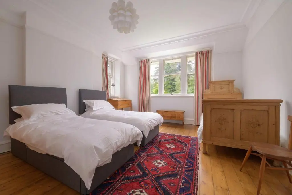 a bedroom with two beds and a rug at Haven Retreat Scotland - Large 4 Bed House with Woodland garden, Aboyne ,Royal Deeside in Aboyne