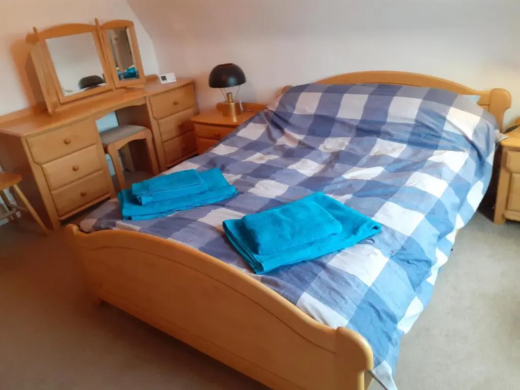 a bedroom with a bed with two blue towels on it at Just off the Square... Ballater in Ballater