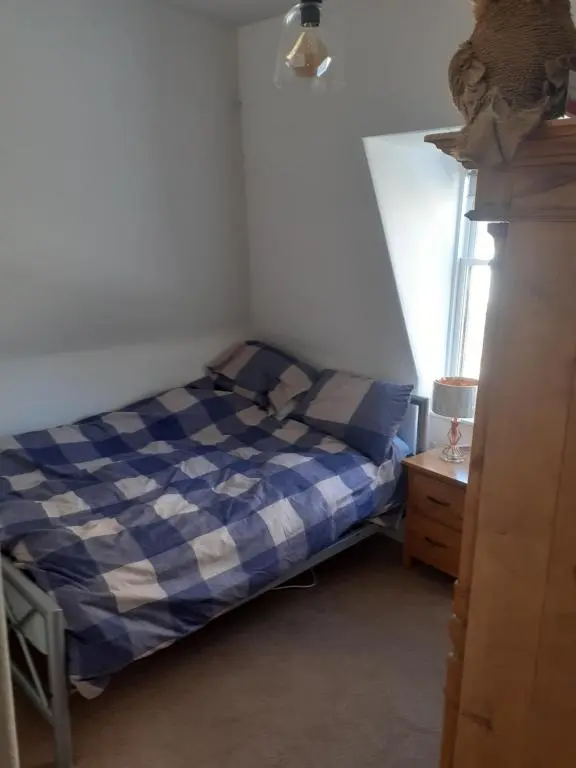 a small bedroom with a bed and a window at Just off the Square... Ballater in Ballater