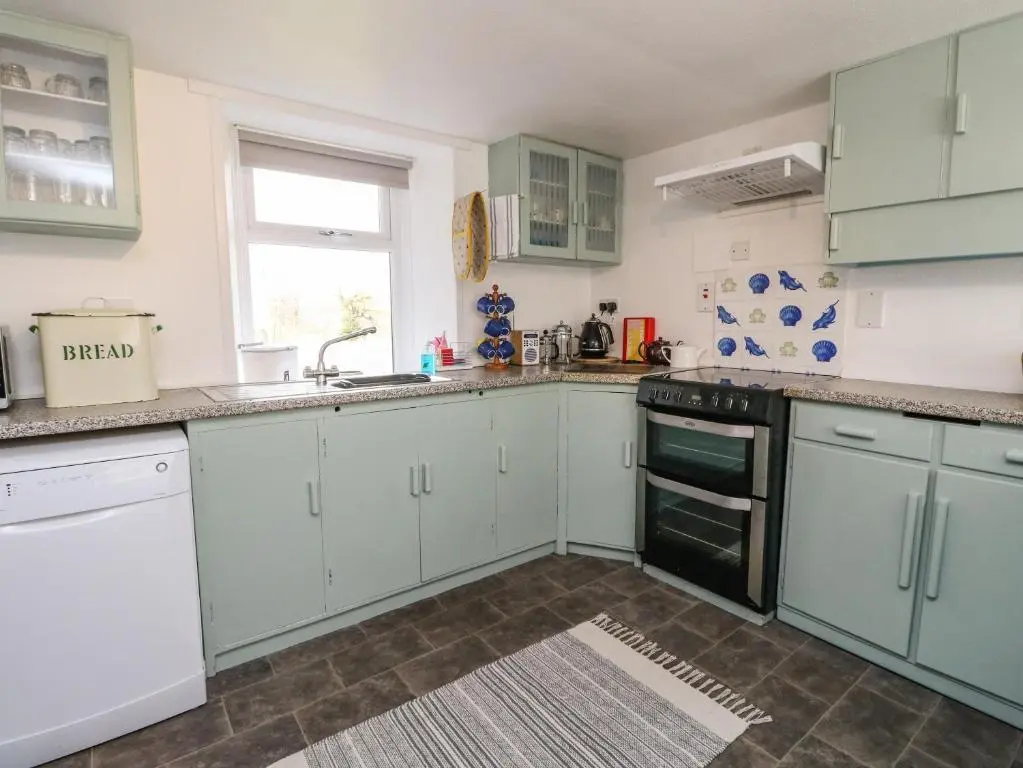 a kitchen with blue cabinets and a sink at Storkery Cottage in Aberdeen