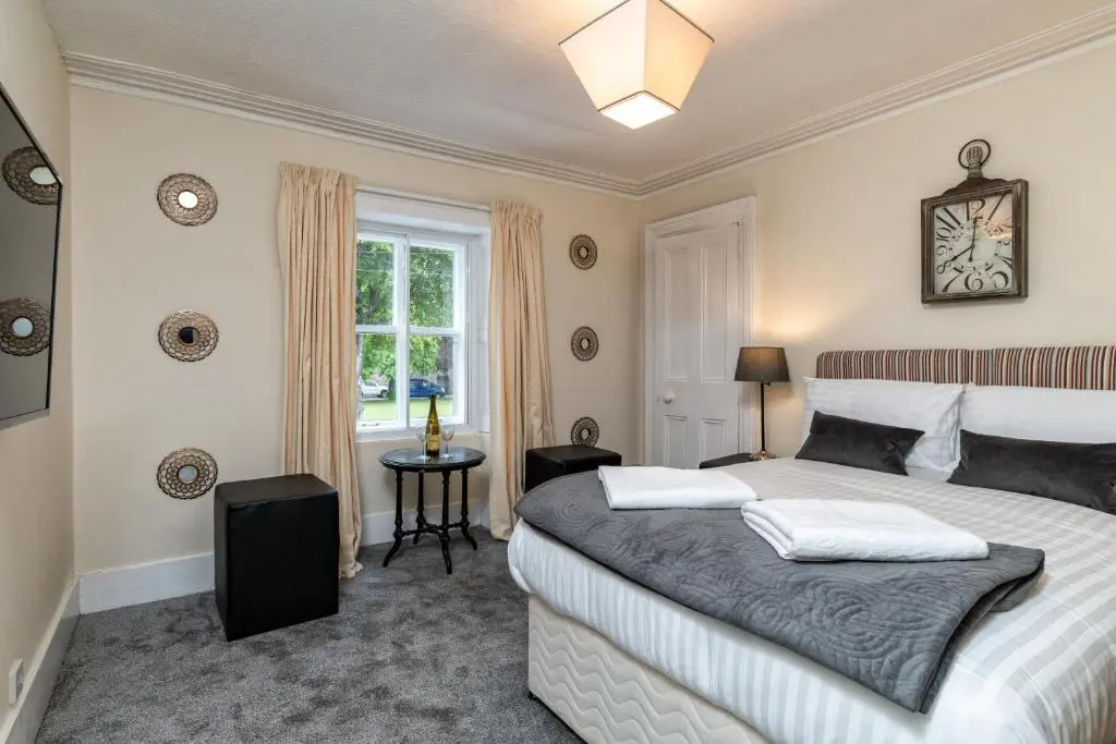 a bedroom with a large bed and a window at The Green Inn Rooms in Ballater