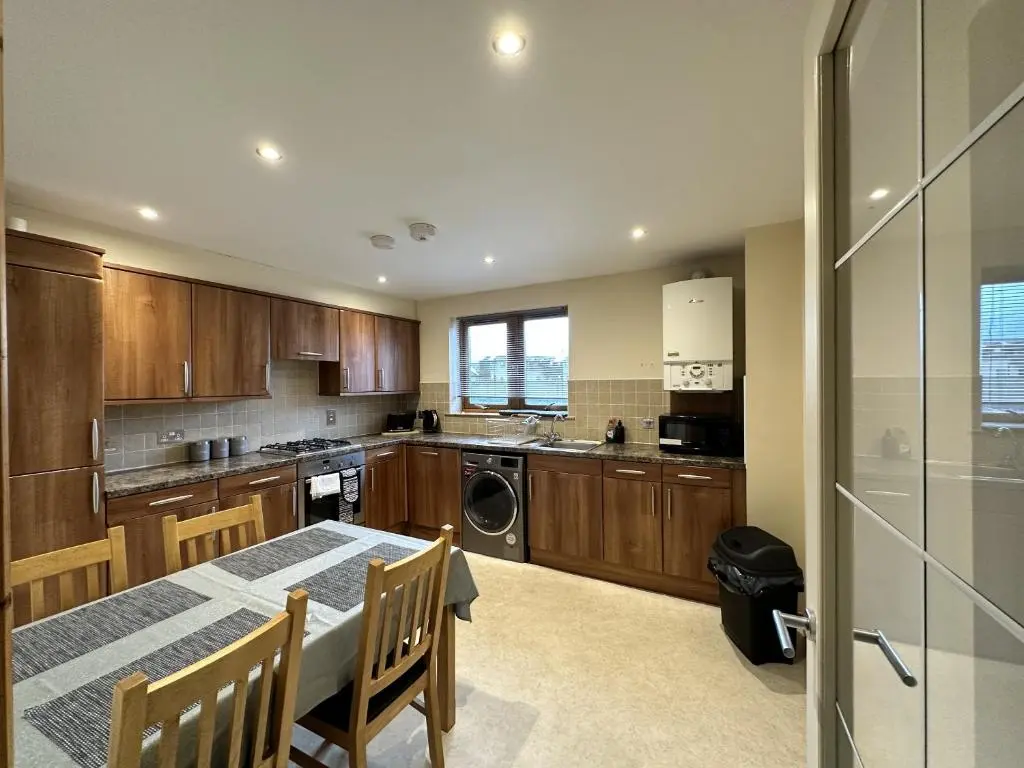 a kitchen with a table and a dining room at Waterside View Apartment in Inverness