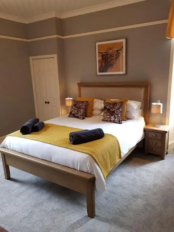 a bedroom with a bed with two pillows on it at Glencoe House Inverness in Inverness