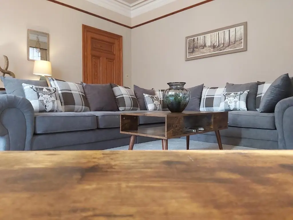 a living room with couches and a coffee table at Glencoe House Inverness in Inverness