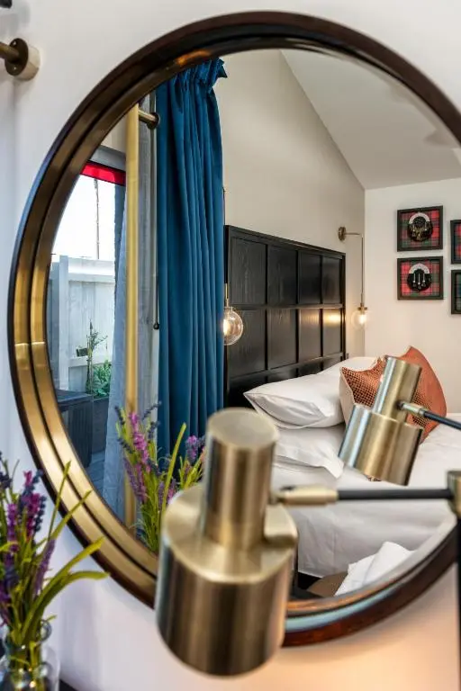 a bedroom with a bed and a mirror at Relax in Super Size Copper Tub - 2 bedroom villa in Inverness