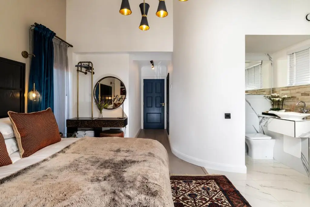 a bedroom with a bed and a sink and a mirror at Relax in Super Size Copper Tub - 2 bedroom villa in Inverness