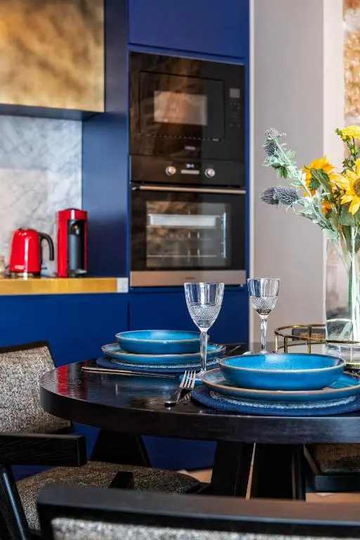 a kitchen with a table with blue plates on it at Relax in Super Size Copper Tub - 2 bedroom villa in Inverness