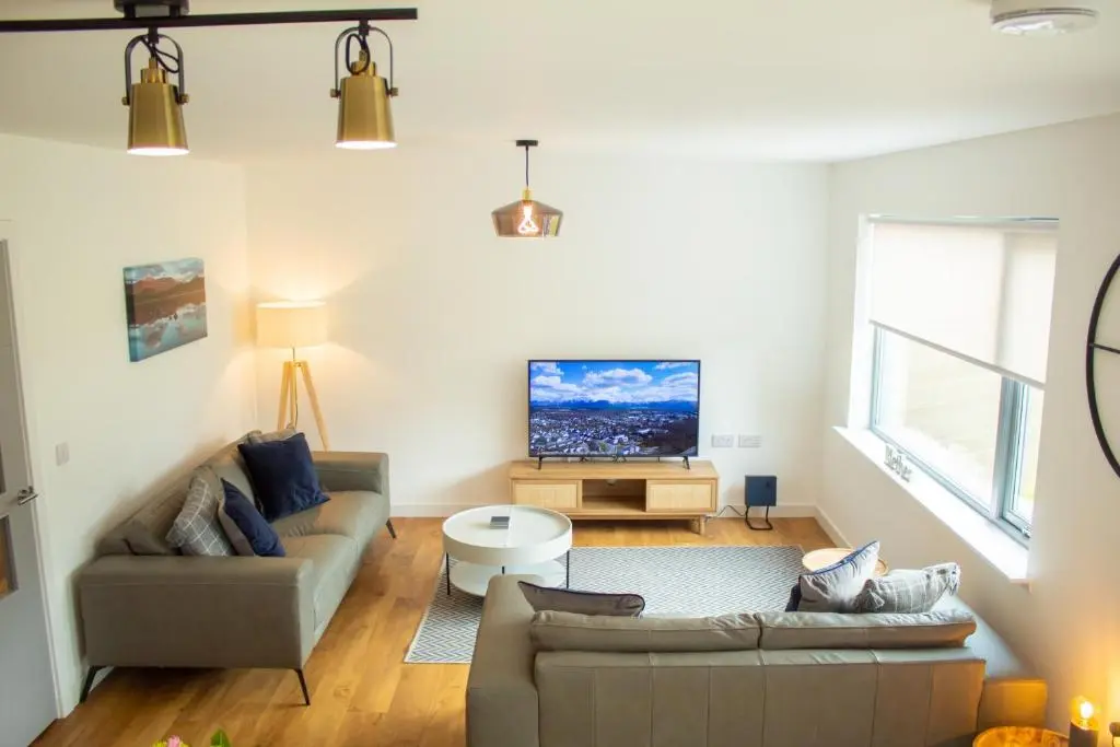 a living room with a couch and a tv at 31 Caledonia Place in Aviemore