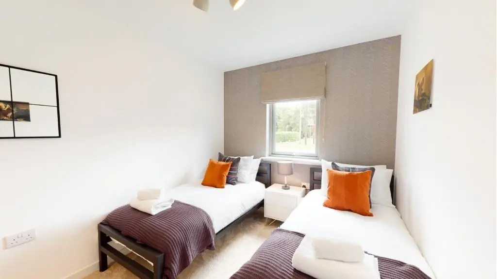 a bedroom with two beds and a window at 31 Caledonia Place in Aviemore