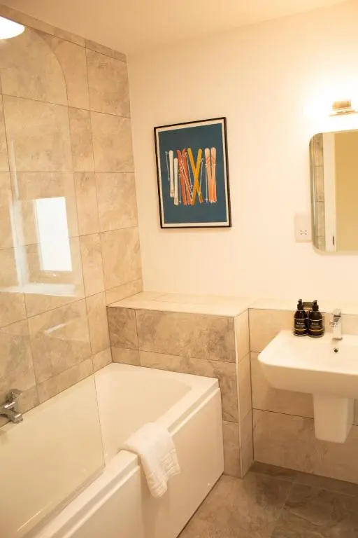a bathroom with a bath tub and a sink at 31 Caledonia Place in Aviemore