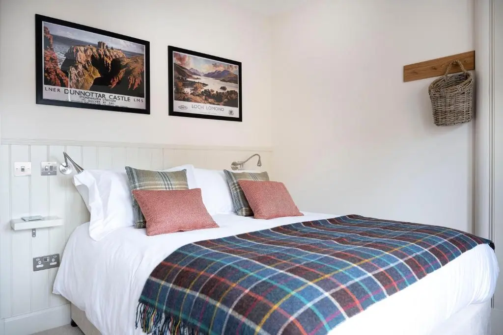 a bedroom with a bed with two pictures on the wall at Art House Apartments in Inverness