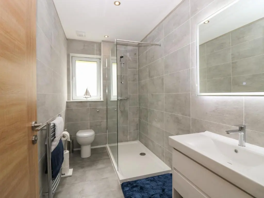 a bathroom with a shower toilet and a sink at Ocean View in Banff