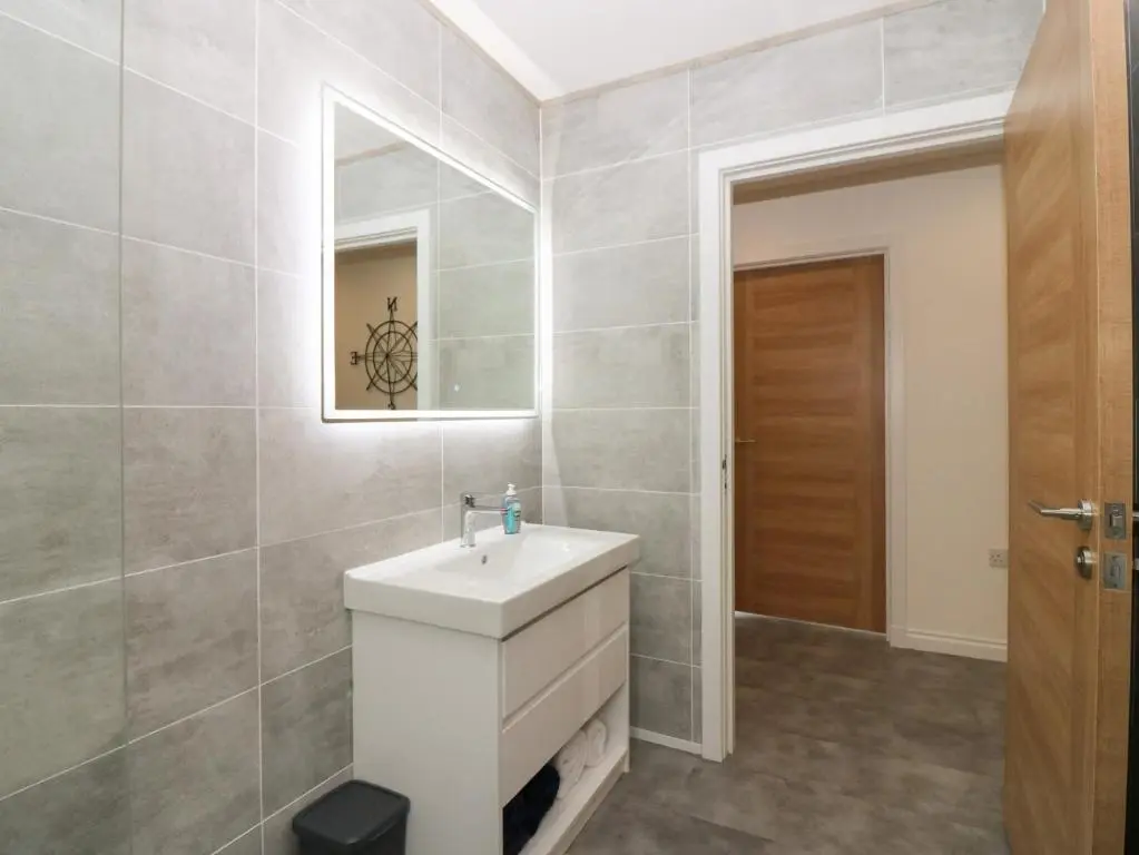 a bathroom with a white sink and a mirror at Ocean View in Banff