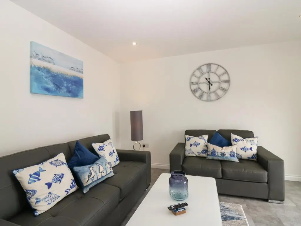 a living room with two couches and a table at Ocean View in Banff