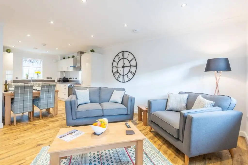 a living room with two blue chairs and a table at Stylish & Modern Apartment in Inverness