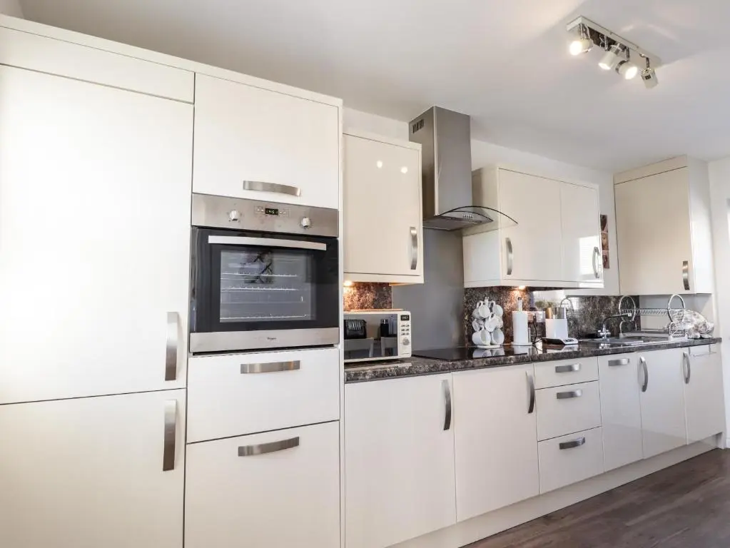a white kitchen with white cabinets and appliances at 38 The Views in Elgin